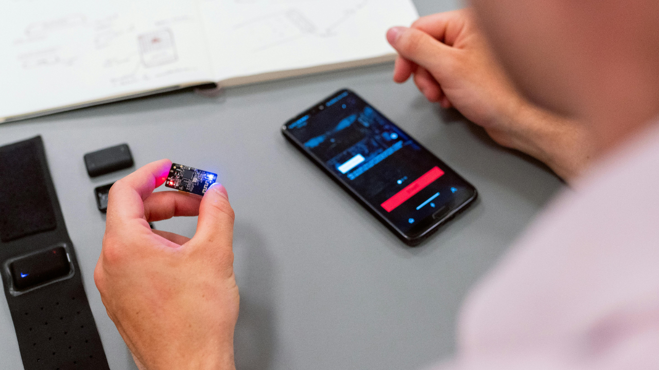 Prototype demonstration showing a small device connected to a mobile phone for Proof of Concept testing.